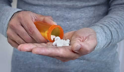 a woman holds pills to represent using klonopin for opiate withdrawal