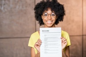 a woman shows off her resume after a resume building workshop in Denver