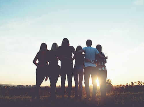 a group of people in our rehab alumni program pose together at sunset