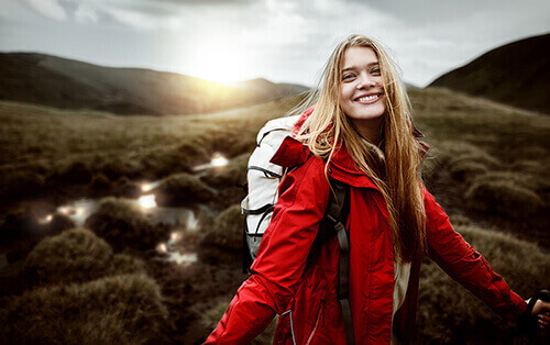 a hiking woman looks happy after learning about Red Rock Recovery Center