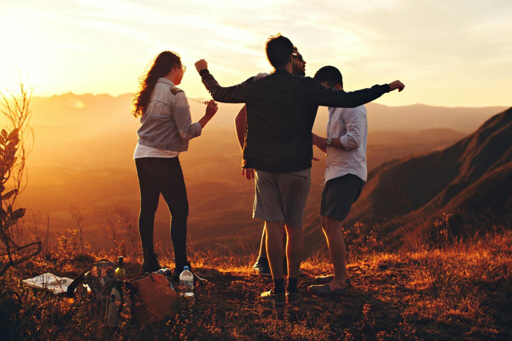 Friends having fun on top of a mountain during dusk