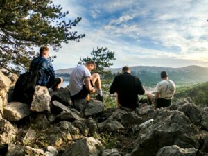 Friends sitting on edge of cliff